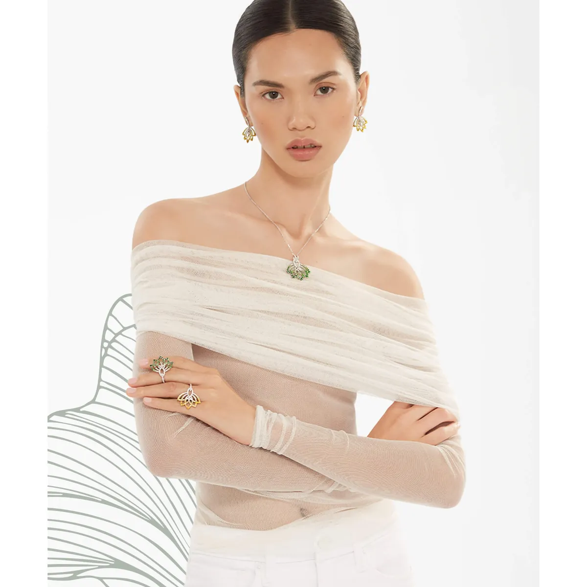 Ein Model trägt einen grünen Lotus-Anhänger von Garrard mit passenden Ohrringen und Ringen